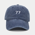 Detail der gewaschenen blauen Baumwolle und weißen 77er Stickerei auf der Baseballkappe - Marineblau