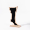 Detailed close-up of a wood and black velvet foot-shaped display stand for jewelry - Black