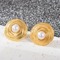 Gros plan de boucles d'oreilles spirales plaquées or 18 carats avec perles blanches - Perle ronde