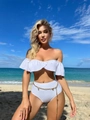 Dettaglio del top bikini bianco con volant e slip a vita alta con cintura a catena oro - S / Bianco