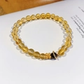Detail eines Natur-Citrin-Blumenarmbands mit goldenem Kleeblatt-Anhänger auf Buchseiten - 5mm Perlendurchmesser (Mit exquisiter Geschenkbox)