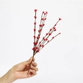 Nahaufnahme roter künstlicher Weihnachtsbeeren-Zweige vor einem schlichten weißen Hintergrund - 30cm Rote Beeren Zweig