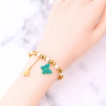 Elegante pulsera de perlas y cuentas doradas con colgante de mariposa verde en la muñeca - Pulsera