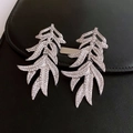 Detailaufnahme der blattförmigen Quastenohrringe mit Kristallen auf schwarzem Leder - Silber (Silberstift)