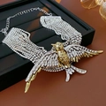 Macro shot of layered necklace showing gold swallow pendant with sparkling rhinestones - Gold & Silver