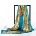 Peacock blue paisley satin square silk scarf displayed on a minimalist metal stand - 90x90cm / Paisley Blue