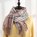 Sciarpa a quadri rosa e grigi effetto cashmere con lunghe frange su un manichino - Rosa