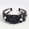 Detalle de diadema de tweed negro con perlas, pedrería y lentejuelas sobre fondo blanco - Tweed/Perla/Diamante de imitación / Negro