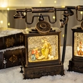 Bronze vintage telephone lantern with internal nativity scene and warm glowing lights - Retro Telephone Nativity Scene