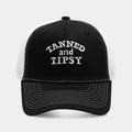 Detail der weißen TANNED and TIPSY Stickerei auf der schwarzen Mesh-Trucker-Kappe - Schwarz und Weiße Krempe