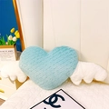 Détail d'un coussin en peluche cœur bleu clair avec des ailes blanches sur un lit blanc - Cœur avec ailes - Vert menthe