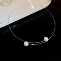 Girocollo minimalista in filo di metallo con due perle bianche su fondo nero riflettente - Girocollo di Perle Argento
