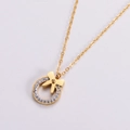 Collana con fiocco dorato e ciondolo rotondo di strass vista da un'angolazione diagonale - Oro