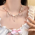Close-up of a sweet pearl necklace with pink bow pendant on model with lace outfit - 6# Colorful Beaded Bow Style