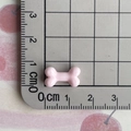 Detailed view of pink resin bone charm on measuring mat showing 1.5cm size scale - Light Pink