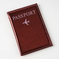 Detail of wine red metallic passport cover with embossed airplane icon and clean stitching - Burgundy