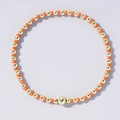 Minimalist handmade beaded bracelet featuring vibrant orange beads and gold-tone metal balls - Orange and Gold