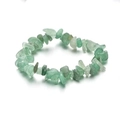Nahaufnahme unregelmäßiger hellgrüner Fluoritsteine auf einem elastischen Steinarmband - Aventurin