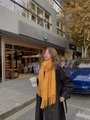 Woman wearing a mustard yellow knitted scarf with tassels and a black trench coat - Thickened Tassel Style (350g) / 200*70cm / Turmeric