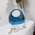 Détail du sac coquillage bleu acrylique avec texture losange et chaîne serpent dorée - Bleu