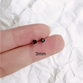 Minimalist 3mm black cubic zirconia stud earrings in 925 silver held for scale - 3mm Black Zircon 1 Pair