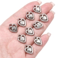 Macro shot of silver plated heart charms for DIY jewelry making held in a hand - Hollow Double Heart / 12x15mm (Hole approx 2mm) - 20pcs/pack / Silver