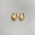 Detailed close-up of gold plated hollow oval earrings on light gray textured surface - Gold Heart/Teardrop Style (DEK1807)