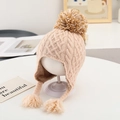 Close-up of beige knit winter hat featuring thick fleece lining and decorative pompoms - 48-52cm (Approx. 1-4 Years) / Pompom/Braids/Fleece Lined / Beige