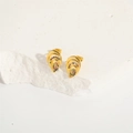 Elegant gold teardrop earrings with colorful gemstones on a white stone background - Multicolor Zirconia