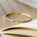 Makroaufnahme eines minimalistischen 18K vergoldeten Rings mit Diamant im Buch - US 5 / Gold Einzelstein