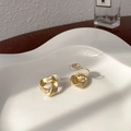 Golden matte twisted geometric clip-on earrings displayed on a white ceramic tray - Matte Gold Twisted Geometric Ear Clip