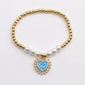 Golden bead and pearl bracelet featuring a blue heart evil eye smiley face pendant - Blue