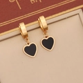 Close-up of golden huggie earrings with black heart charms on a beige velvet texture - Black Heart Huggie Hoop Earrings (3#耳环)