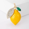Close-up of a lemon brooch with yellow enamel texture, emerald leaves and clear crystals - Yellow