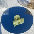 Detail showing marble pattern on light green acetate hair claw clip with mirror reflection - Aloe Ice