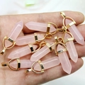 Natuurlijke roze kwarts zeshoekige hangers met gouden kappen in de hand getoond - Rozenkwarts