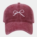 Dettaglio del ricamo a fiocco bianco su cappellino da baseball in cotone bordeaux lavato - Borgogna