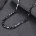 Detalle macro de cadena negra con eslabones geométricos sobre superficie de piedra - 21cm / Negro