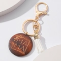 Details vom hölzernen Mama Schlüsselanhänger mit Leopardenmuster, Quaste und Goldkarabiner - Kaffeebraun