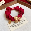 Détail d'un chouchou rouge plissé avec un pendentif dragon doré et une petite médaille - 36# Elastique-Rouge-Cheval-Prospérer