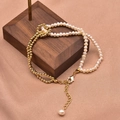Double-strand freshwater pearl and gold bead bracelet with extender on wooden stand - Contrast Color Bracelet