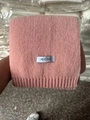 Close-up of pink knitted winter scarf with Feiding brand tag and soft wool texture - Dusky Pink