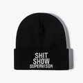 Black knit beanie with white Shit Show Supervisor embroidery on plain background - One Size / Black