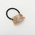 Detalle de anillo metálico de oro rosa trenzado en goma de pelo negra elástica - Pequeño / Oro rosa