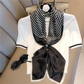 Elegante foulard in seta da 90 cm a righe bianche e nere annodato a fiocco su top bianco - Nero