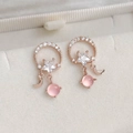 Macro shot of rose gold star and moon earrings with cubic zirconia and pink cat eye stones - 27# 25276 Rose Gold Star Moon Cat Eye Pendant