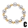 Detailed macro view of two-tone high-polish gold and silver beaded bracelet - C-Gold and Silver Two Tone Beads