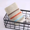 Absorbent beige cotton towel with colorful stripes rolled in a black wire basket - Weak Twist Dotted Satin Green / 34*74cm