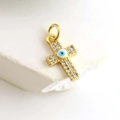 Close-up of gold-plated cross pendant with pavé crystals and blue evil eye detail - Micro Pave Blue Eye Long Cross