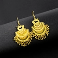 Detail view of gold layered fan-shaped earrings with tassel charms on black texture - Gold 3-Layer Phoenix